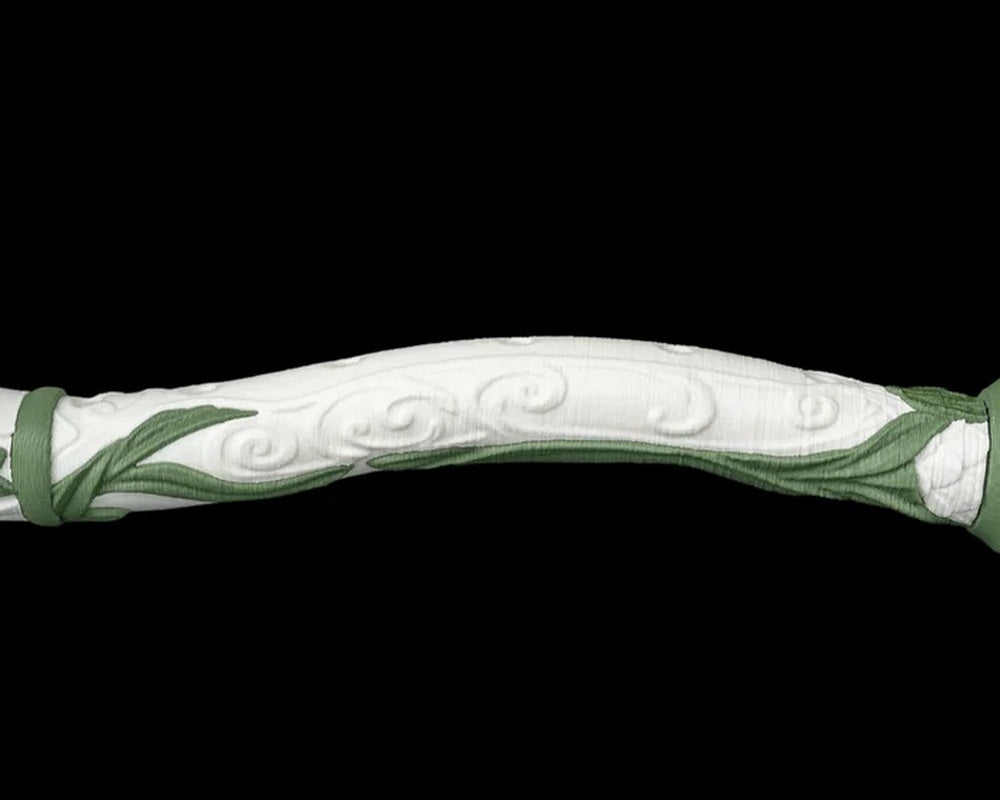Close-up of a curved white body section with green leaf accents and swirl details
