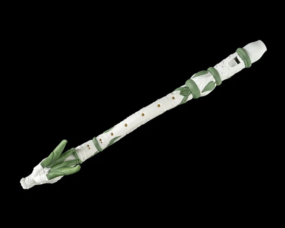 Angled view of the white and green dragon-shaped flute figurine with small round holes
