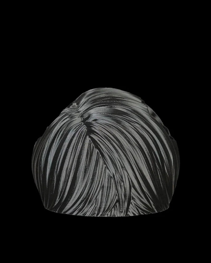 Black bangs piece shown from the back on a black background.