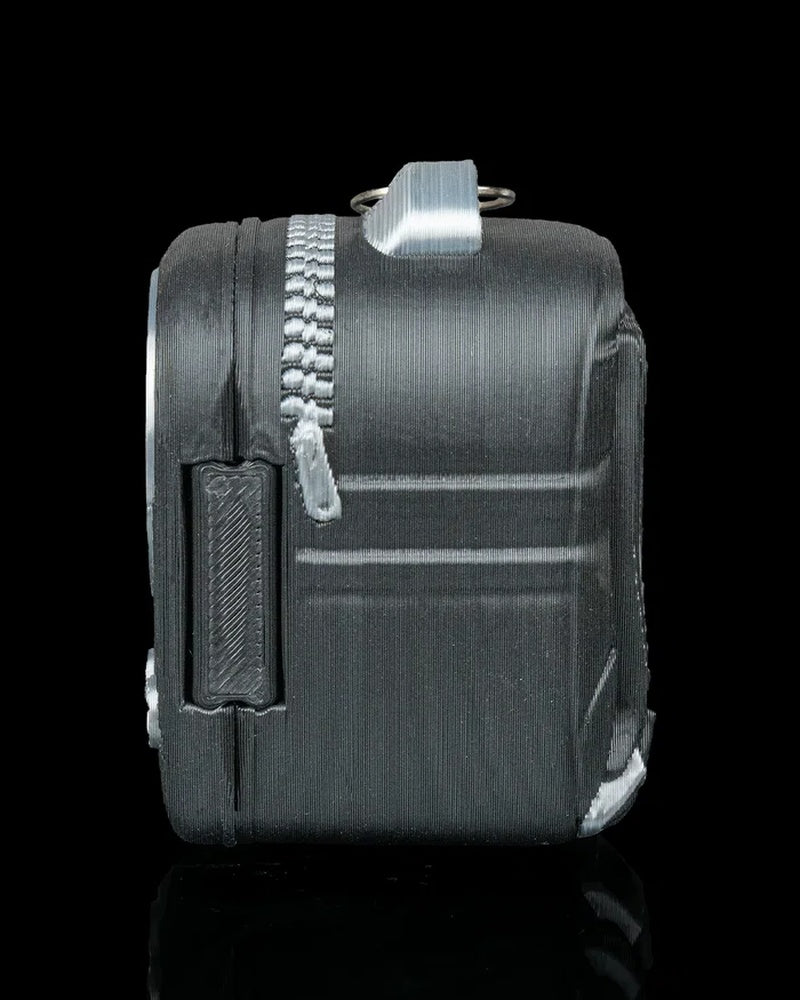 Side view of a dark backpack-shaped figure with zipper-like details and a top loop