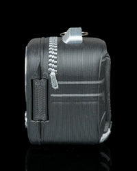 Side view of a dark backpack-shaped figure with zipper-like details and a top loop