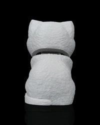 Back view of a seated grey cat figure on a black background