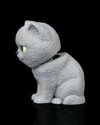 Side view of a seated grey cat facing left with yellow eye visible