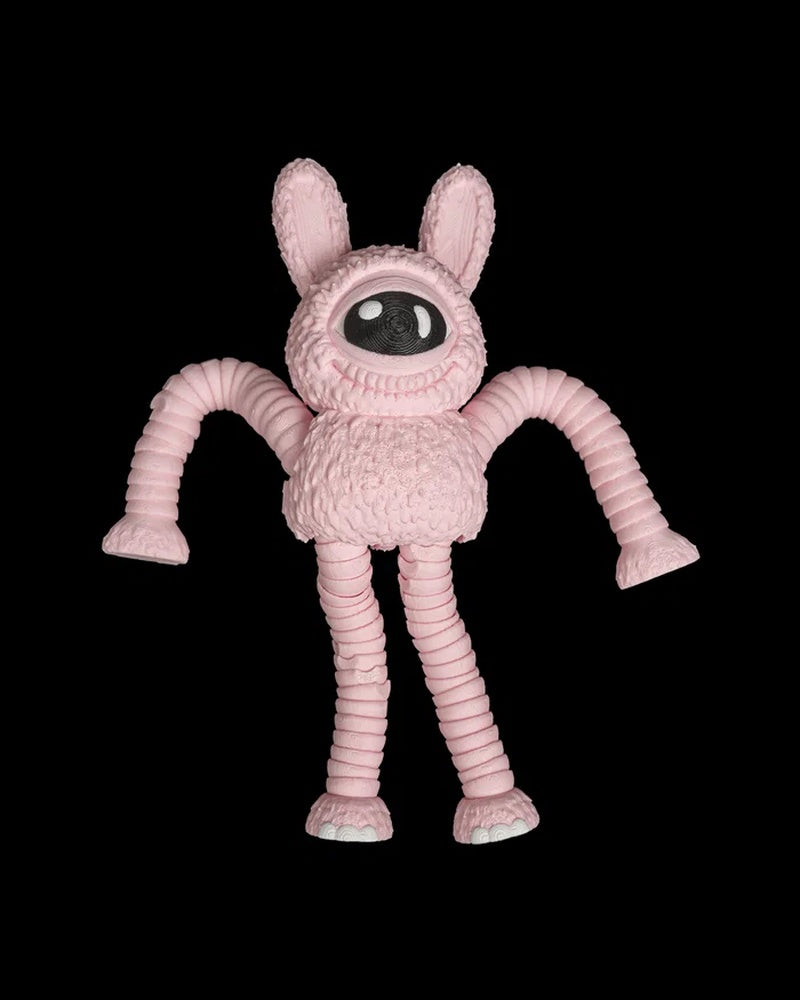 Pink one-eyed monster figurine with tall ears and long ribbed arms on a black background