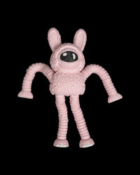 Pink one-eyed monster figurine with tall ears and long ribbed arms on a black background