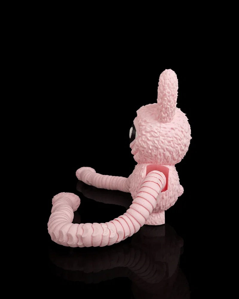 Side view of a pink one-eyed monster figurine with long ribbed arms on a black background