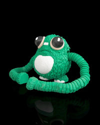 Green frog fidget sitting with long segmented arms curled forward on a black background