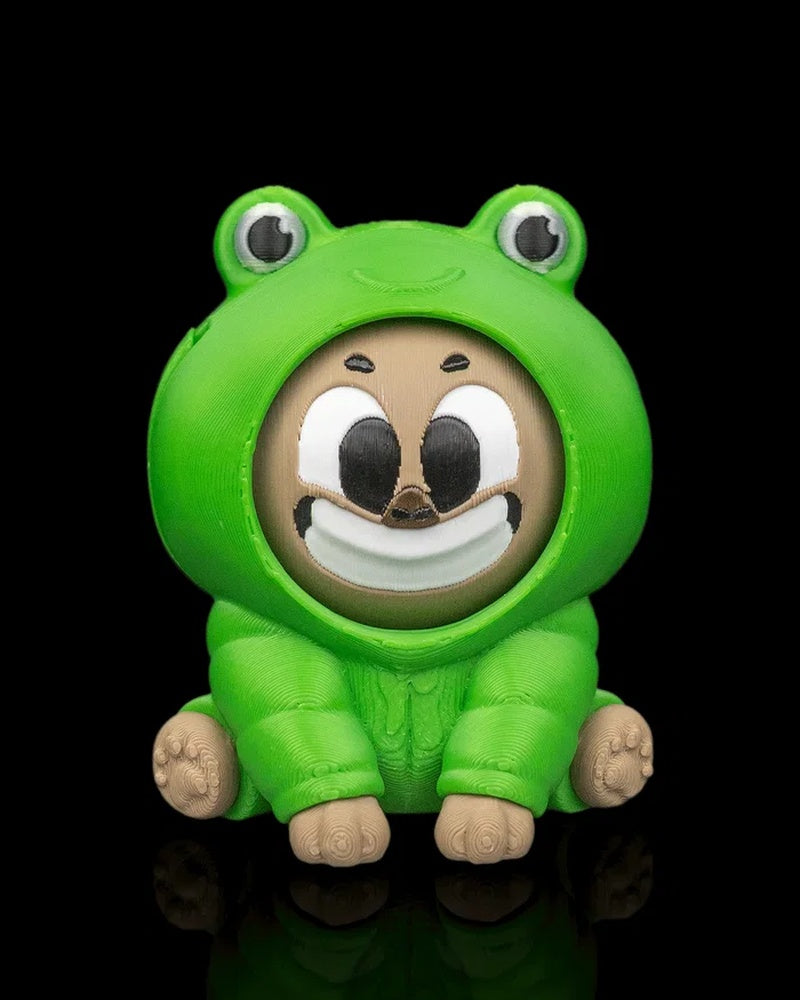 Front view of a green frog-themed capybara figurine with a smiling face on a black background.