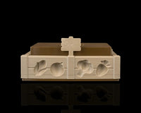 Front view of a tan garden bed tray with raised vegetable shapes, brown insert, and small sign.