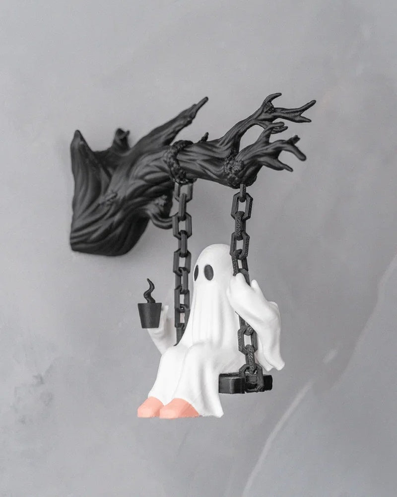 Angled view of a white ghost figurine on a black swing holding a small dark cup-like object