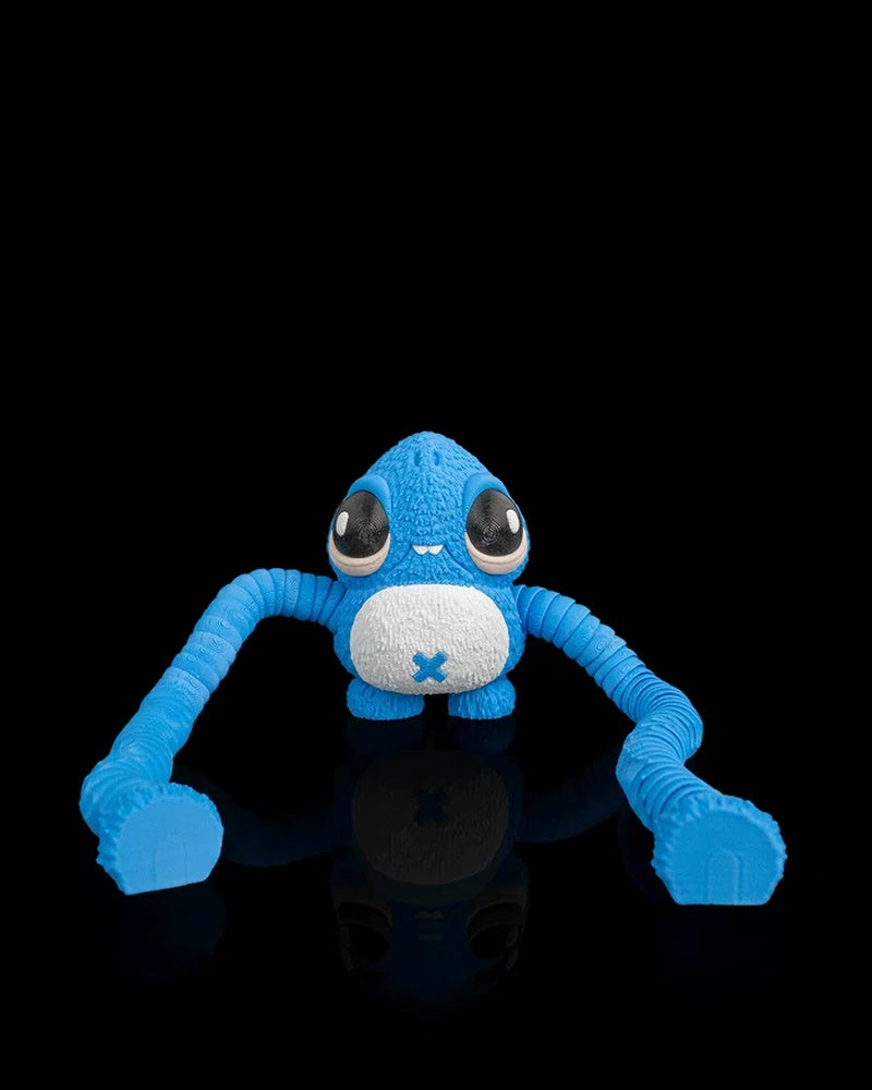Blue monster figurine seated with long ribbed arms stretched forward on a black reflective surface