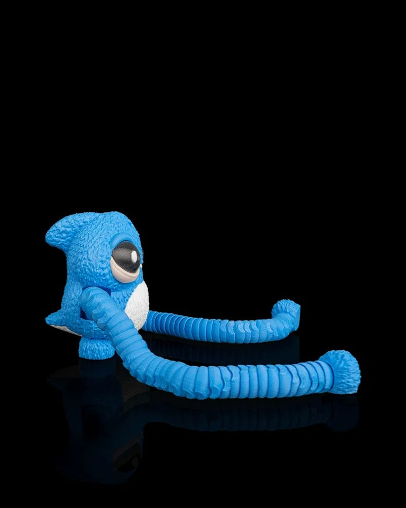 Side view of a blue monster figurine with long ribbed arms curled forward on a black reflective surface