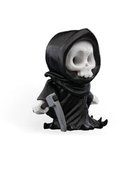 Angled side view of a black robed skull figure with a gray blade-like prop and white hands.