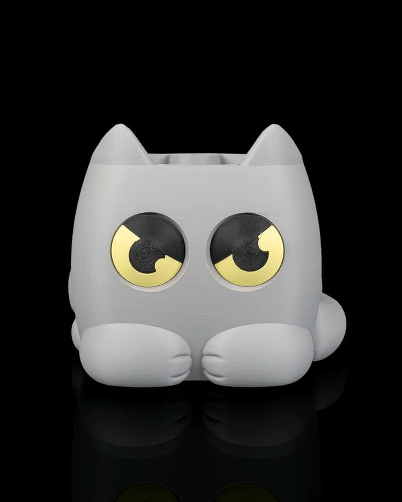 Gray cat-shaped planter with yellow-and-black eyes on a black background