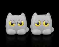 Two gray cat-shaped planters with yellow-and-black eyes side by side