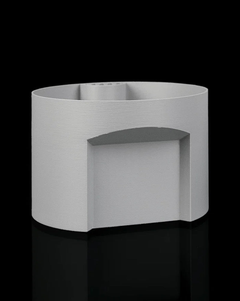 Separate gray cylindrical insert piece on a black background