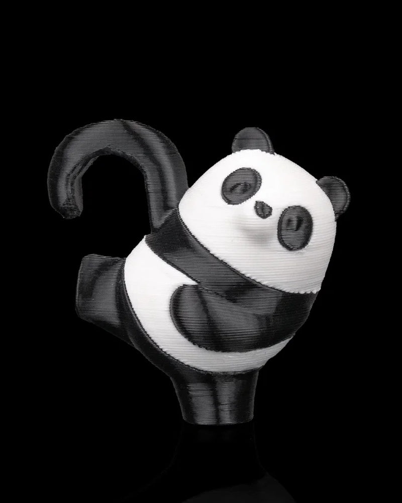 Black and white panda figurine in a hanging pose on a dark background