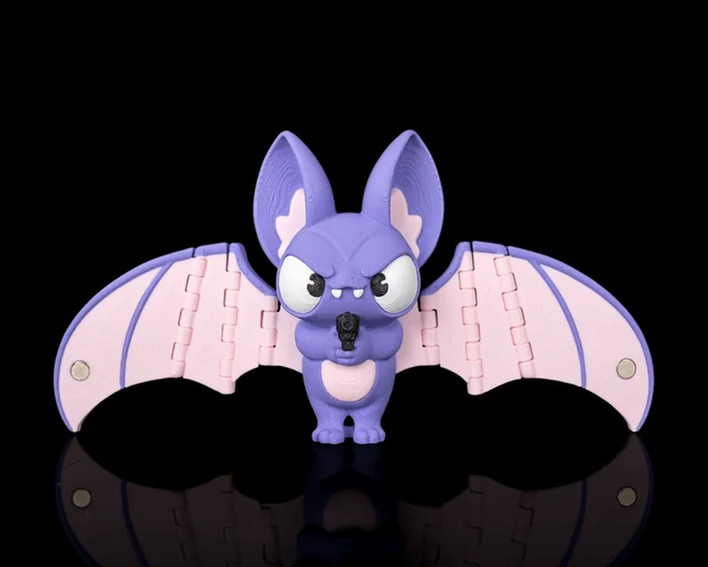 Purple bat figurine with pink wings spread wide on a black background