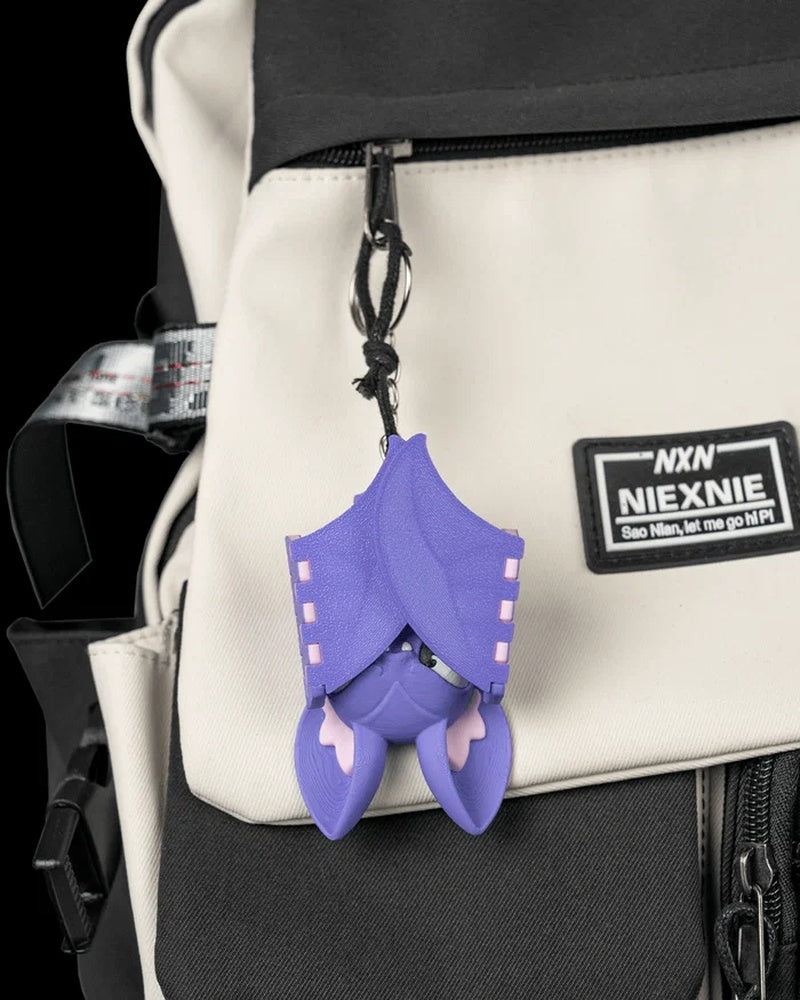Purple bat with folded wings hanging from a backpack