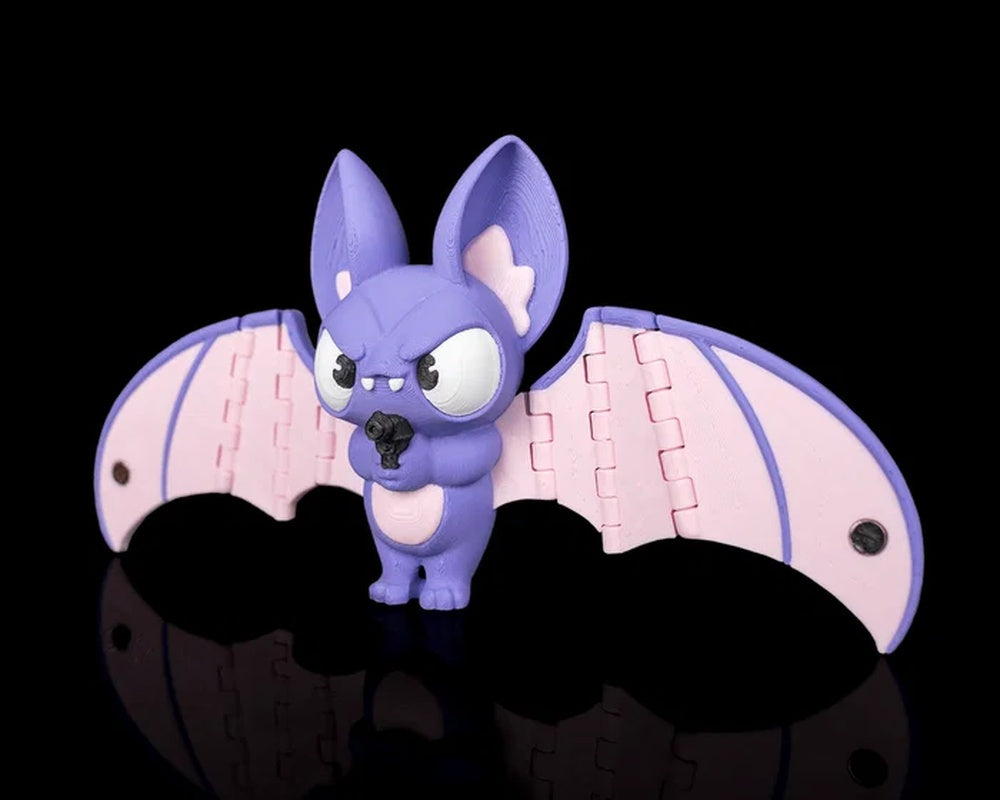Angled view of a purple bat figurine with pink wings on a black background