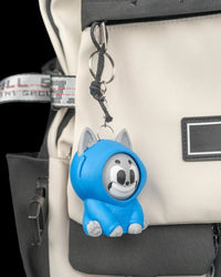 Blue hooded cat toy hanging from a metal ring and chain on a backpack