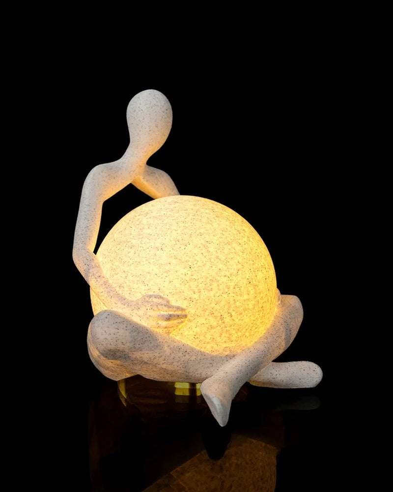 Side view of an abstract seated figure wrapped around a glowing orb