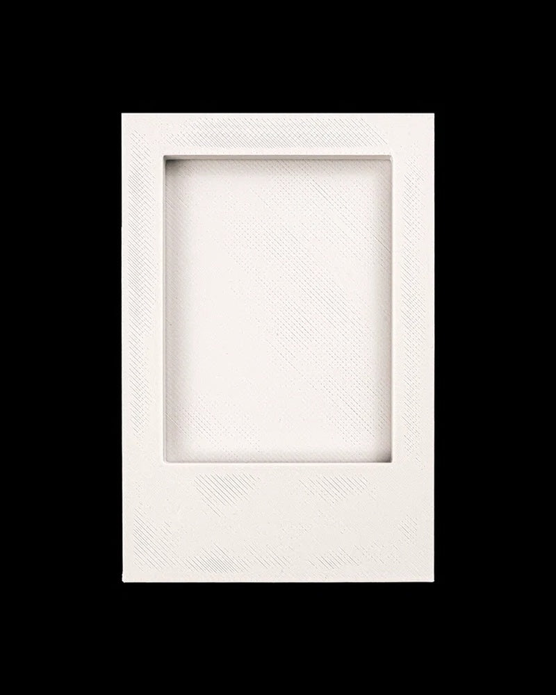 Empty white rectangular photo frame with recessed opening on a black background