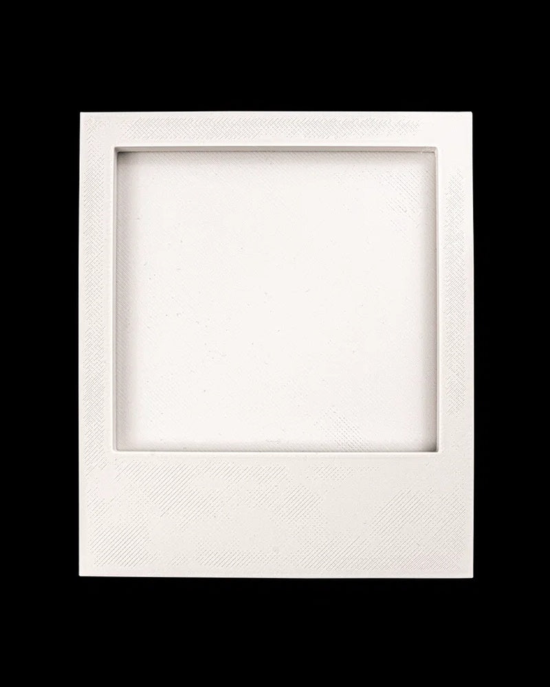 Empty white square photo frame with recessed opening on a black background