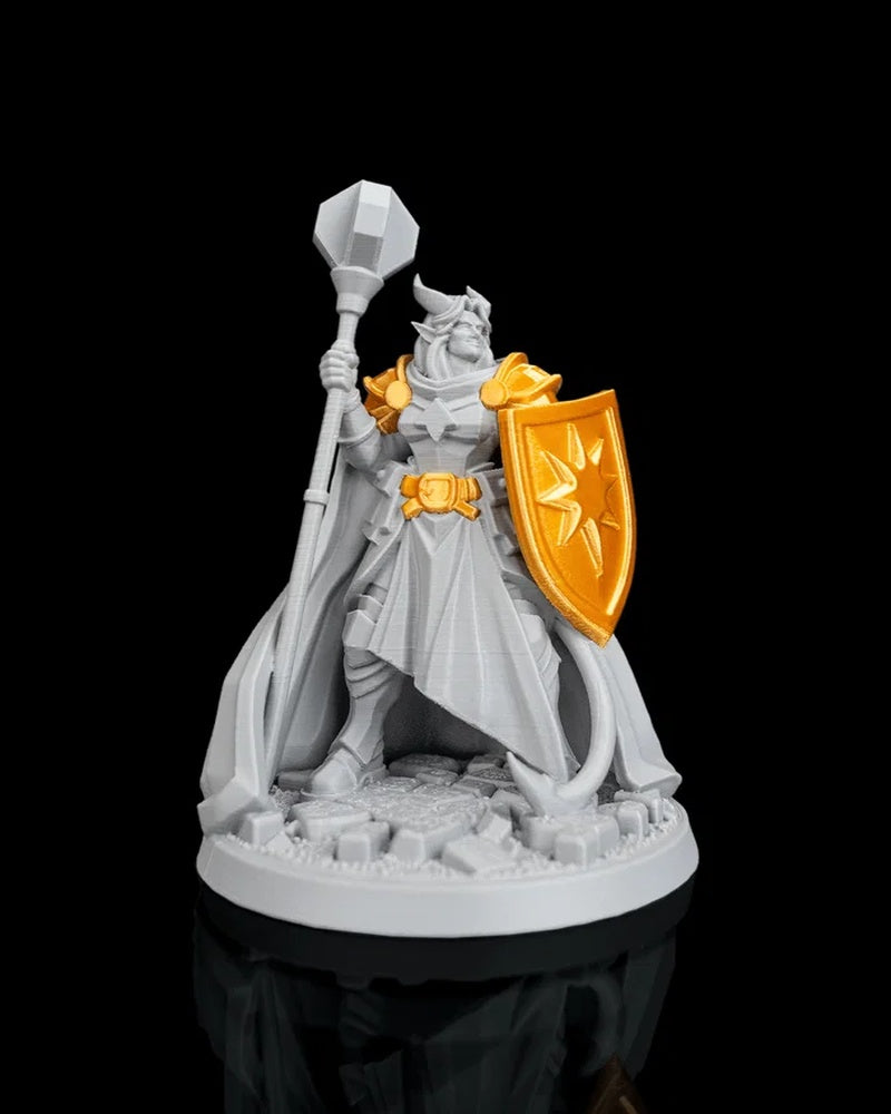 Front view of a horned robed figurine with gold shoulder armor, belt, and shield