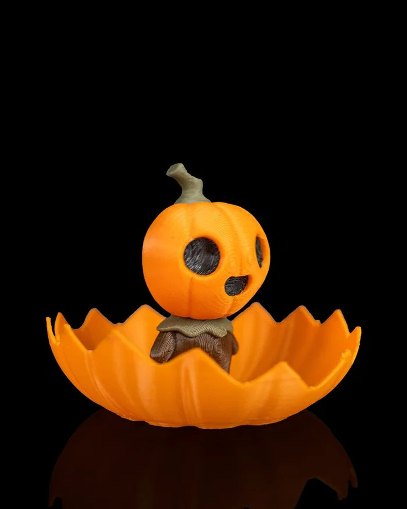Side view of an orange pumpkin character figurine seated in a jagged shell on a black background