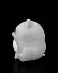 Side rear view of a gray cat figure with one visible ear, side paw, and rounded body.