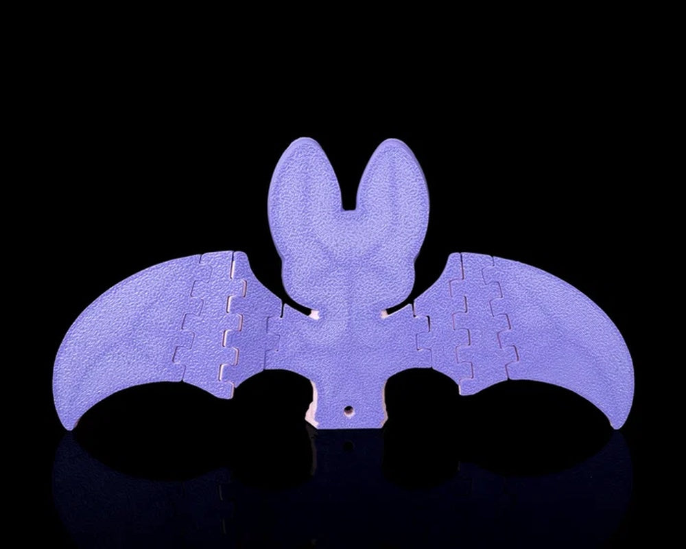 Back view of a purple bat figure with outstretched wings on a black background