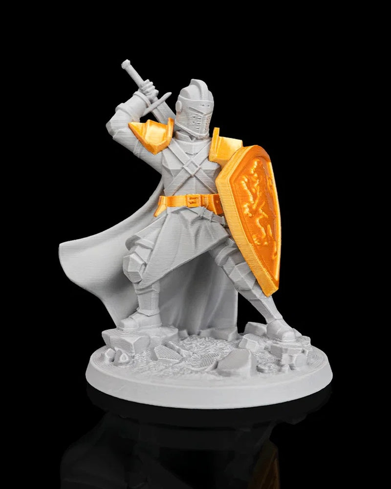 Front view of gray knight figurine with gold shield, belt, and shoulder armor on a round base