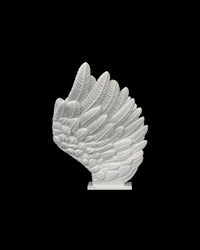 Side view of a white feather-style wing piece on a black background