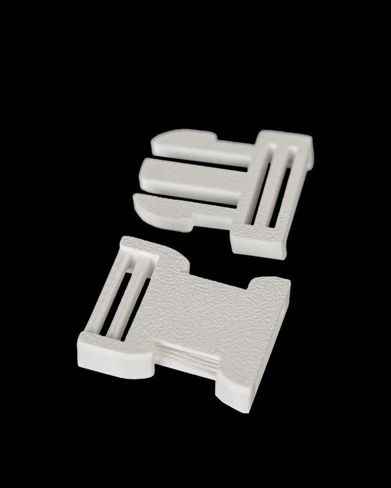Two small white parts shown separately on a black background