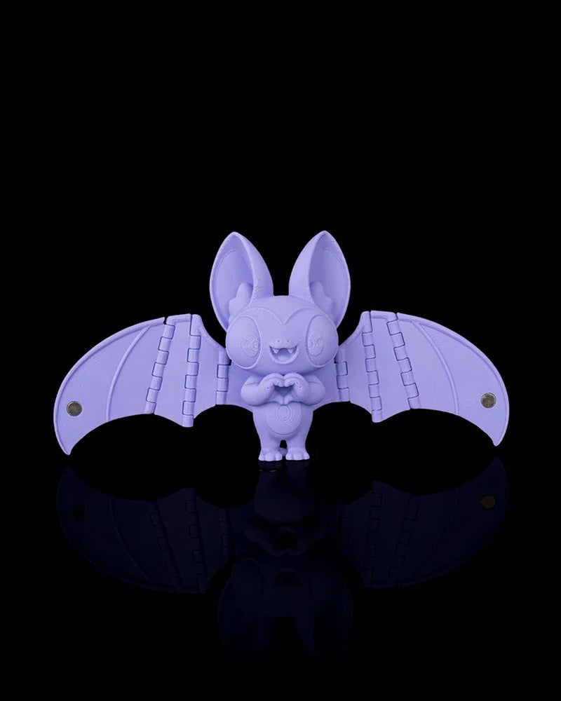 Purple bat figurine with open wings on a black background