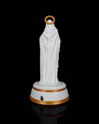 Rear view of a robed statue on a round base with a gold halo ring against a black background