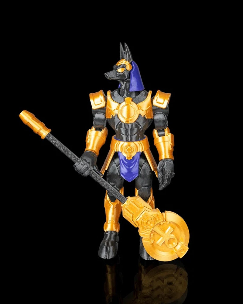 Black and gold jackal-headed figurine holding a long staff on a black background.