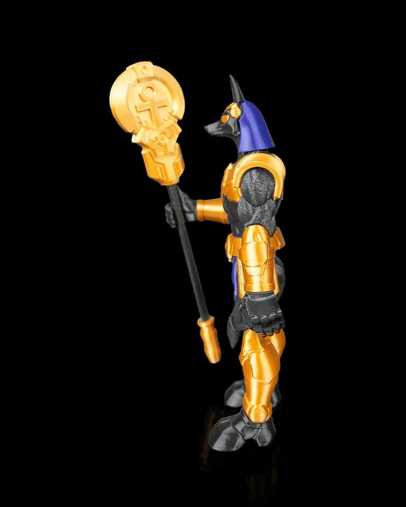 Side view of a black, gold, and blue jackal-headed figurine holding a staff.