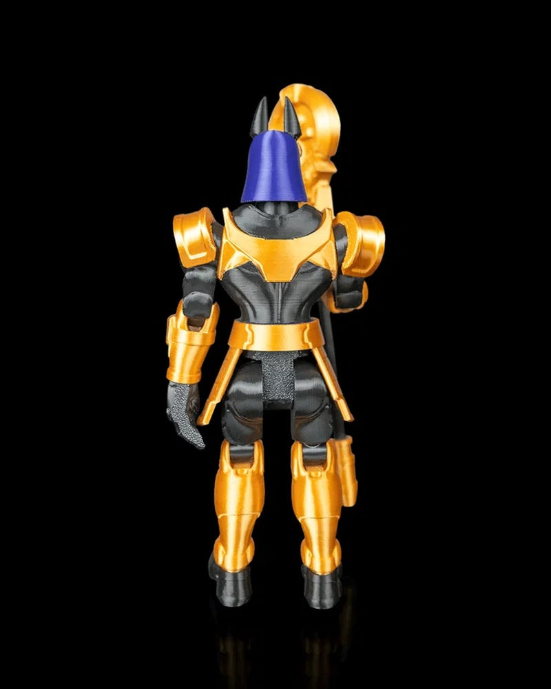 Rear view of a black, gold, and blue armored jackal-headed figurine on a black background.