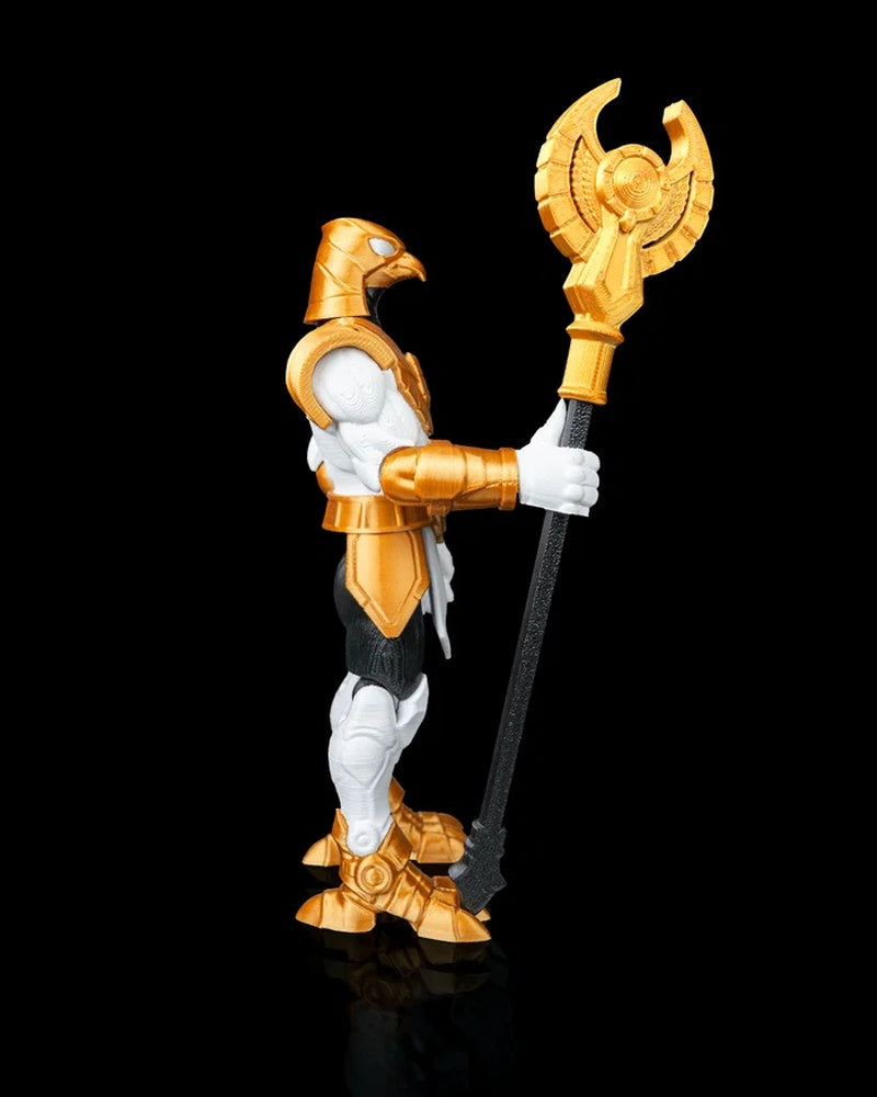 Side view of a falcon-headed armored figurine holding a tall black staff with a gold-colored blade top.