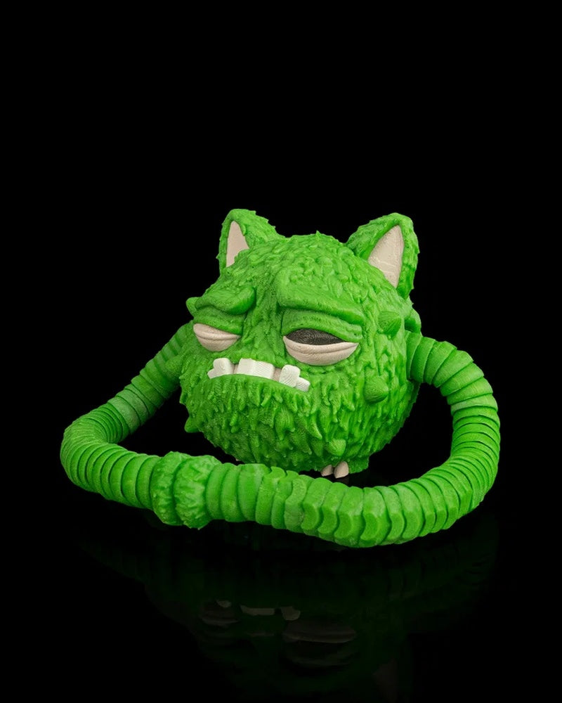 Green creature figurine with long ribbed arms curled in front of its furry round body on a black background
