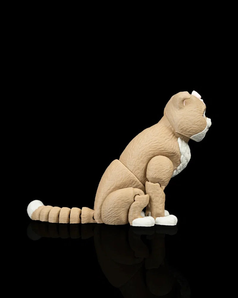 Side view of a tan and white cat figurine with a ringed tail on a black background