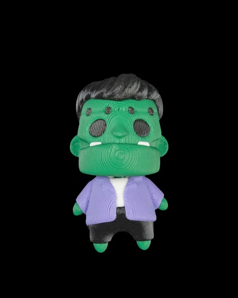 Front view of a green monster figurine with dark hair and a purple jacket on a black background