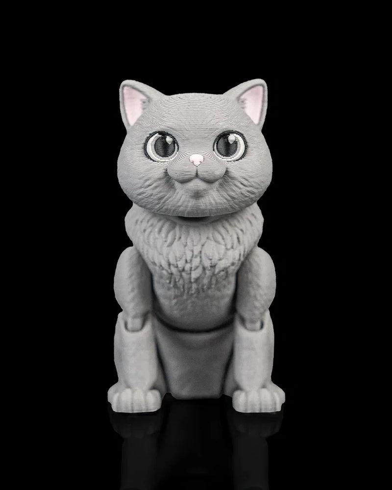Gray cat figurine facing forward on a black background with large eyes and pink ears.