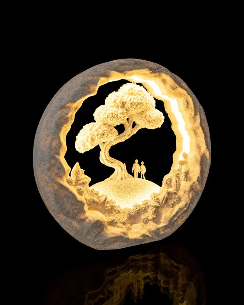 Illuminated circular landscape lamp with a tree and two small standing figures