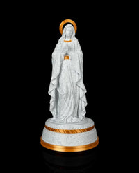 Front view of the statue on a round pedestal with gold-tone trim against a black background.