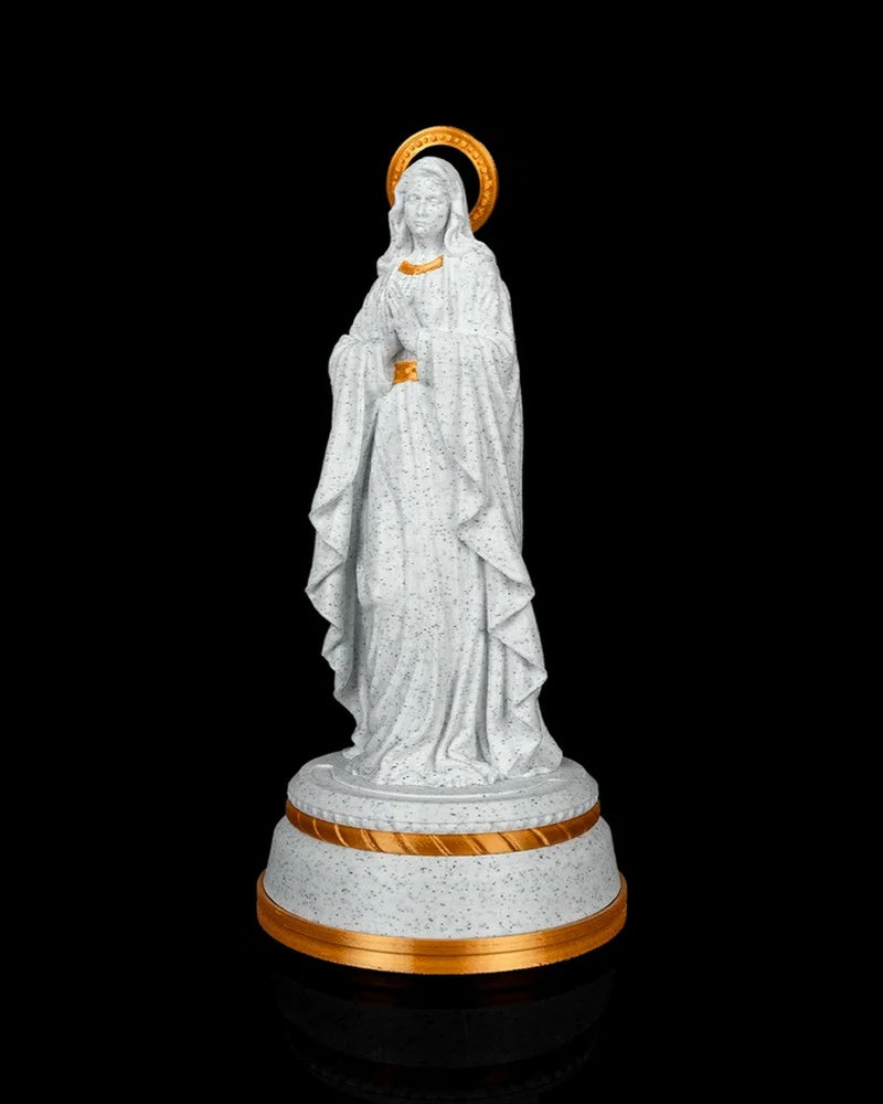 Angled front view of the white speckled statue with draped robes and gold-tone base trim.