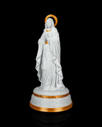 Angled front view of the white speckled statue with draped robes and gold-tone base trim.