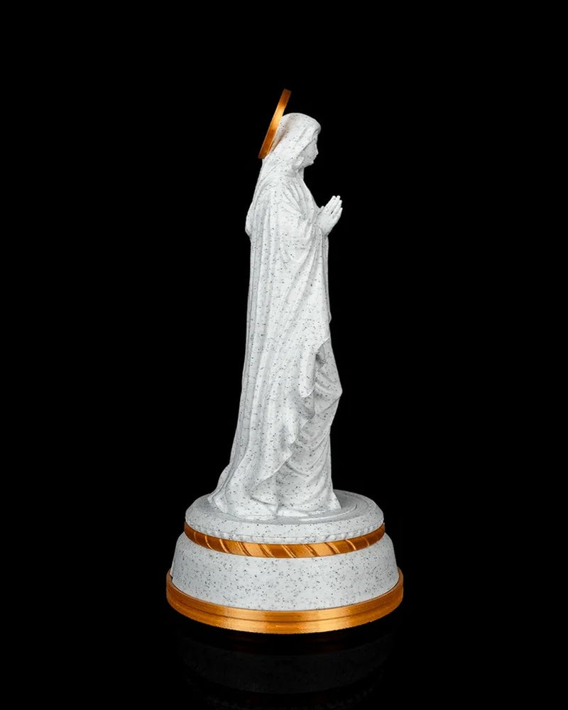 Side view of the statue showing the hooded profile, folded hands, halo, and round base.